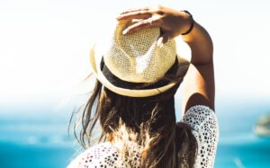 Vrouw met hoed aan zee