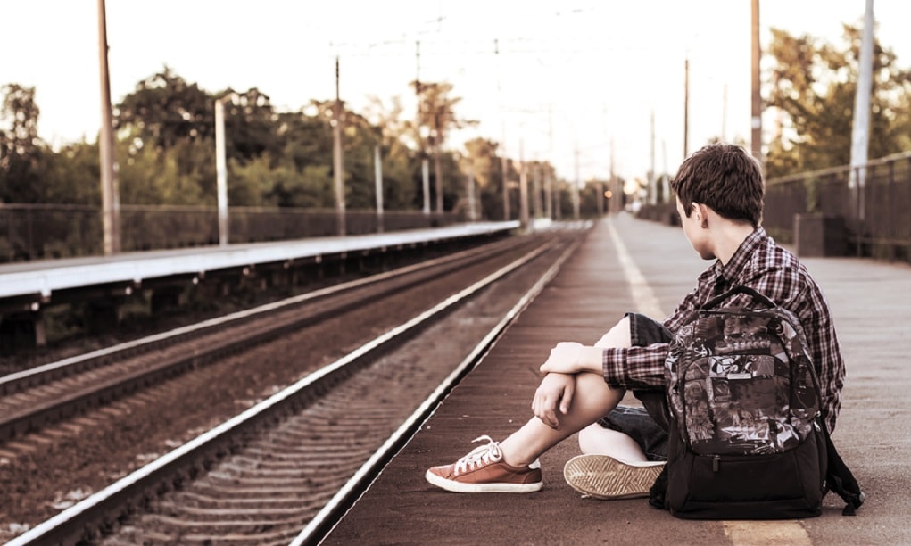 eenzaam jongetje bij de trein