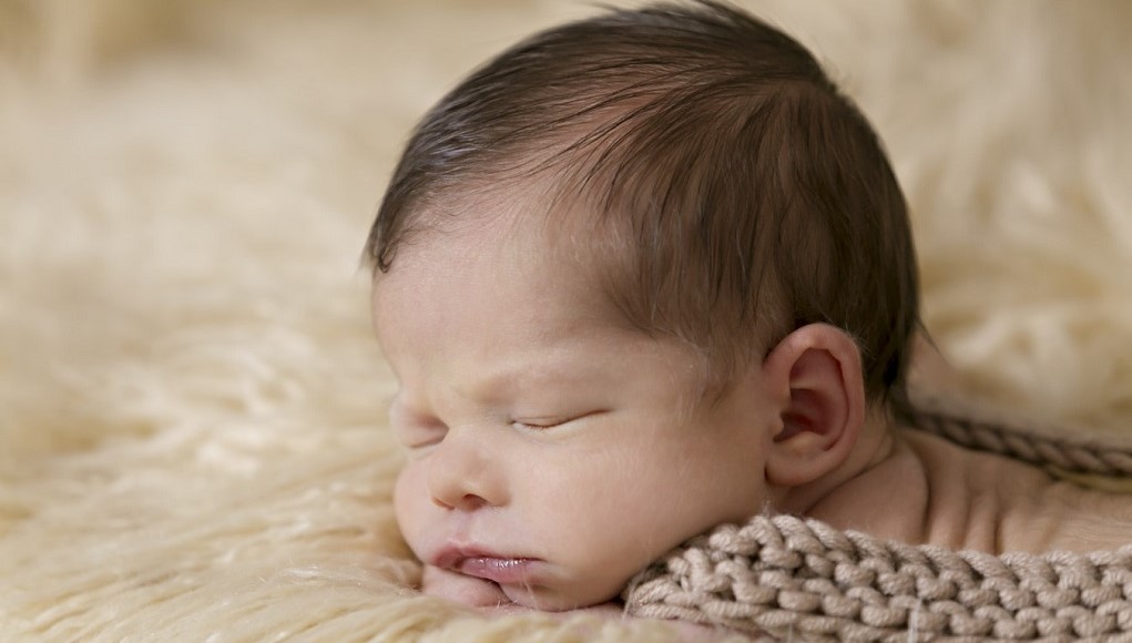 Slapende baby op een schapenvachtje