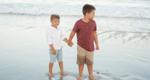 Oudere broer en jongere broer samen aan het strand