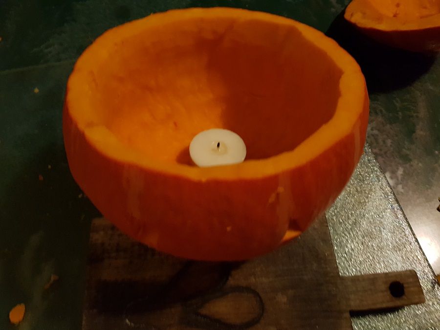 Waxinelichtje in een uitgeholde pompoen om een lantaarn te maken voor Halloween