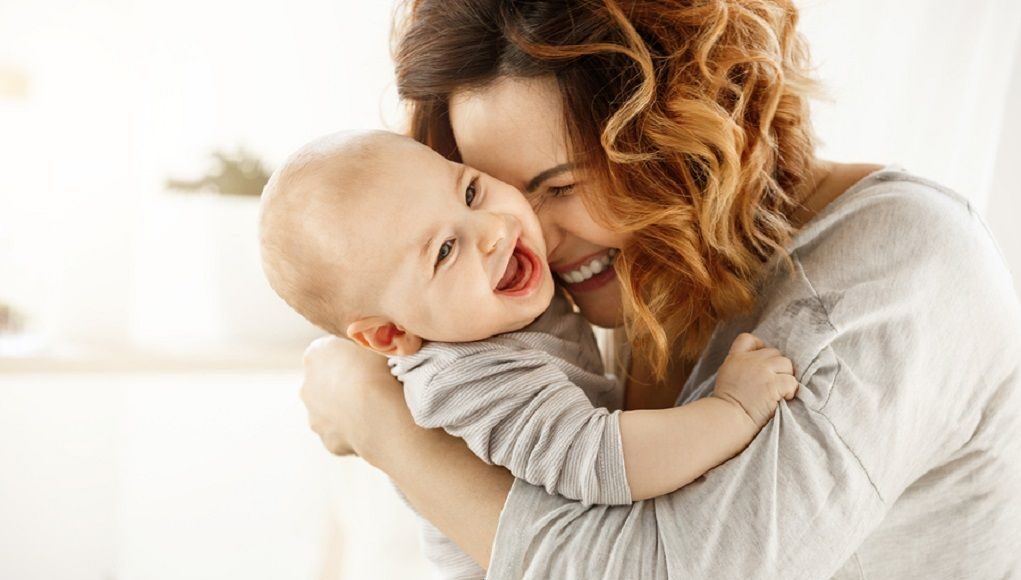 Voel je veilig als mama met de juiste zorgverzekering voor je kinderen, net als deze moeder die haar kindje knuffelt