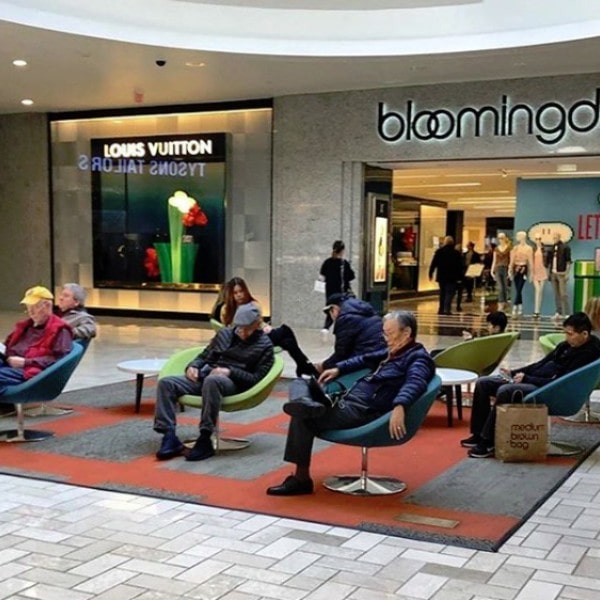 Mannen wachten op vrouw terwijl zij shopt