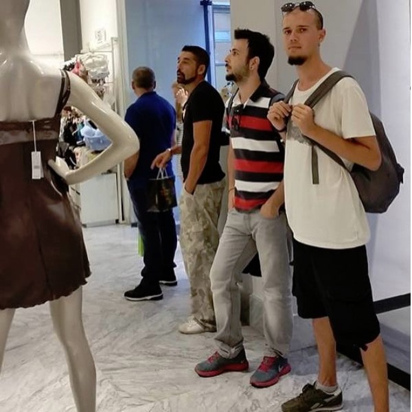 Mannen wachten op vrouw terwijl zij shopt