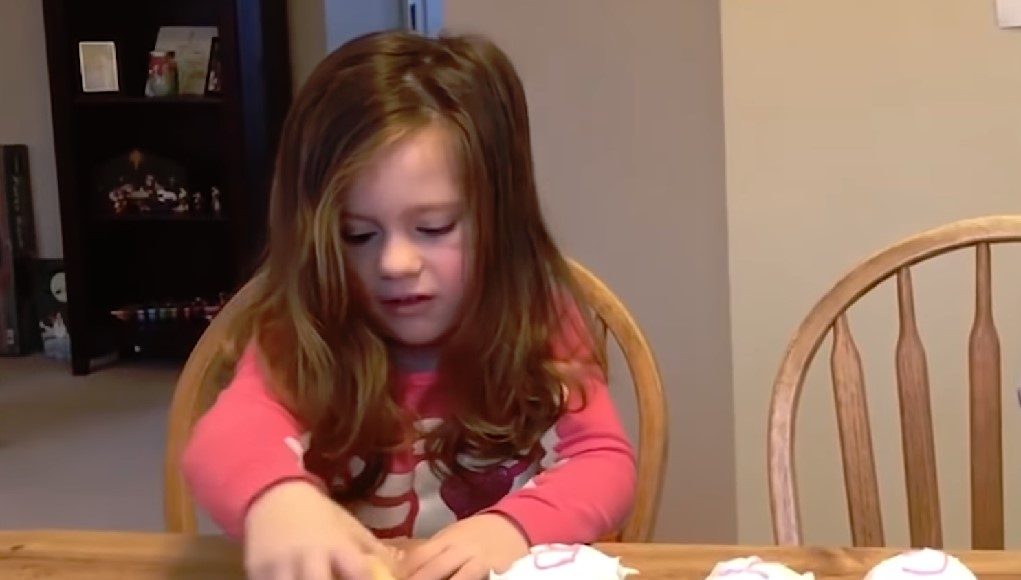Klein meisje probeert cupcake voor gender reveal nieuwe baby