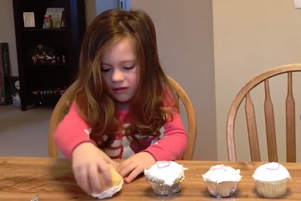 Klein meisje probeert cupcake voor gender reveal nieuwe baby