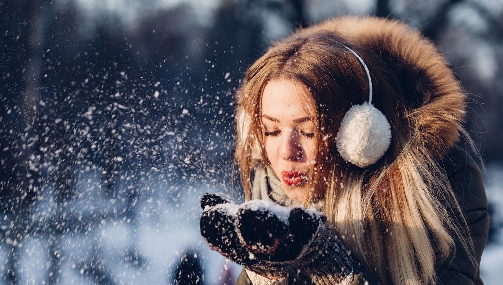 Vrouw blaast magische sneeuw weg zoals in kerstfilms
