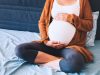 Vrouw denkt op bed na over zorgverzekering als je zwanger bent