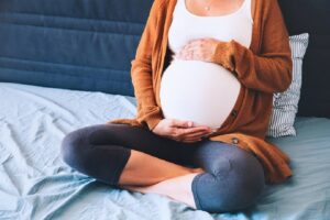 Vrouw denkt op bed na over zorgverzekering als je zwanger bent