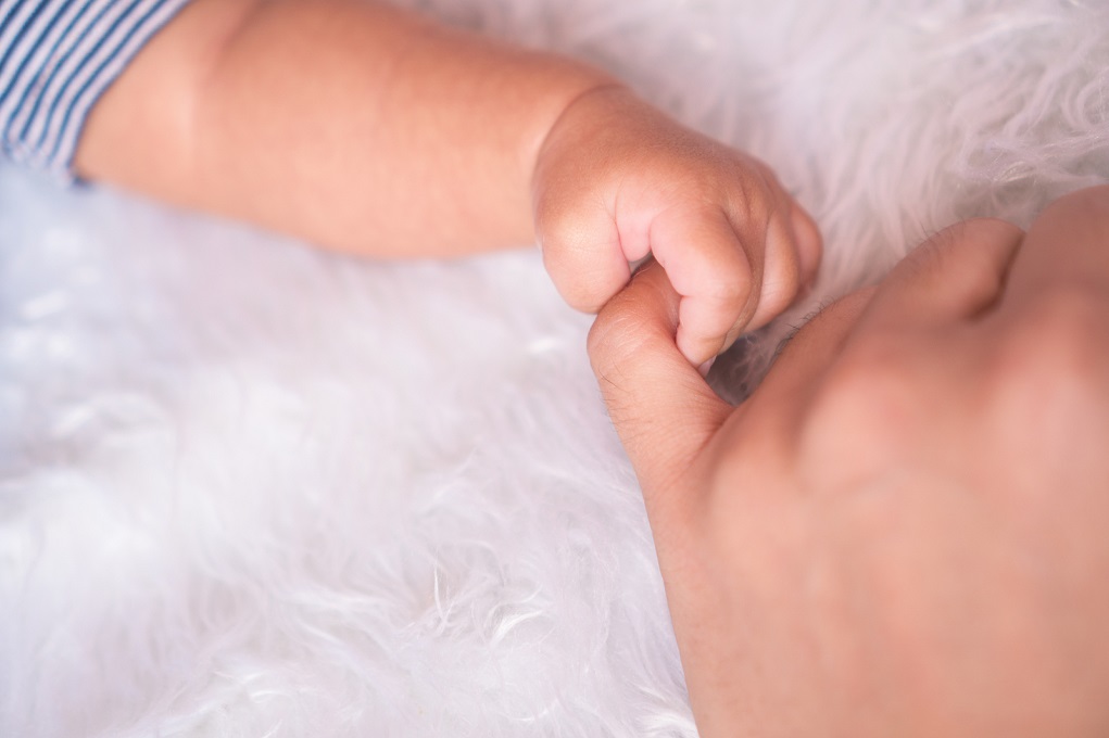 Babyhandje in volwassen hand
