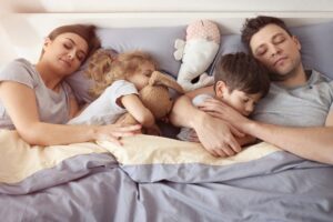Gezin slaapt samen in bed tijdens vakantie