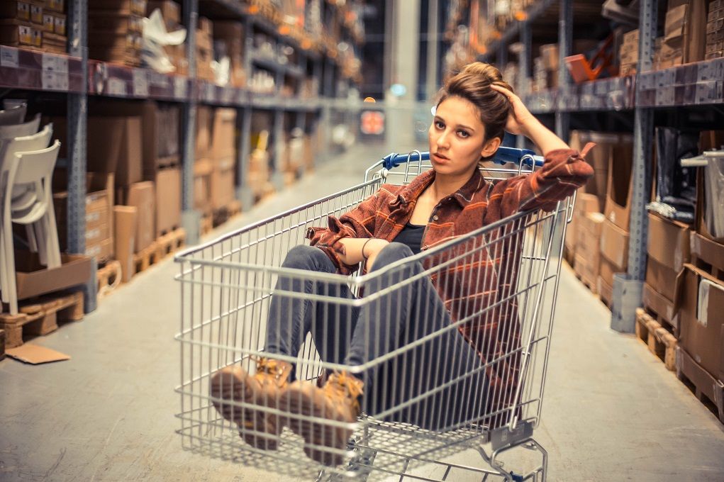 Vrouw in supermarktwagentje, moe na driftbui kind