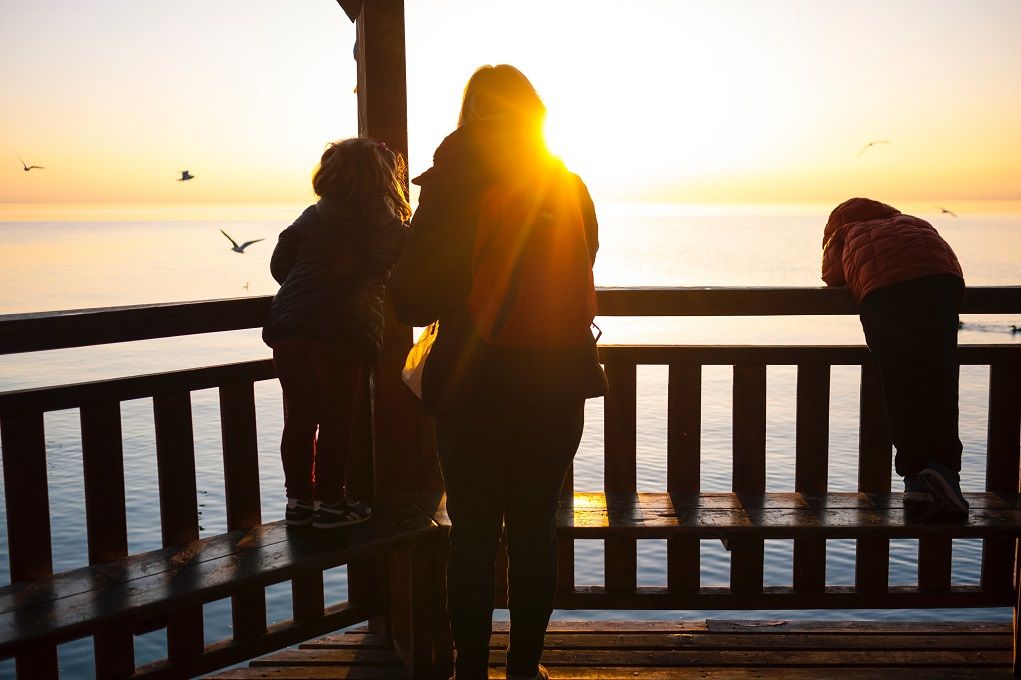 Moeder op reis met haar kinderen kijkt uit over water