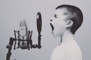 Zelfverzekerd kind schreeuwt/zingt in een microfoon