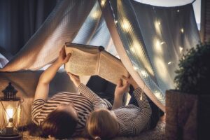 Moeder leest verkorte sprookjes voor aan haar dochter in een tent