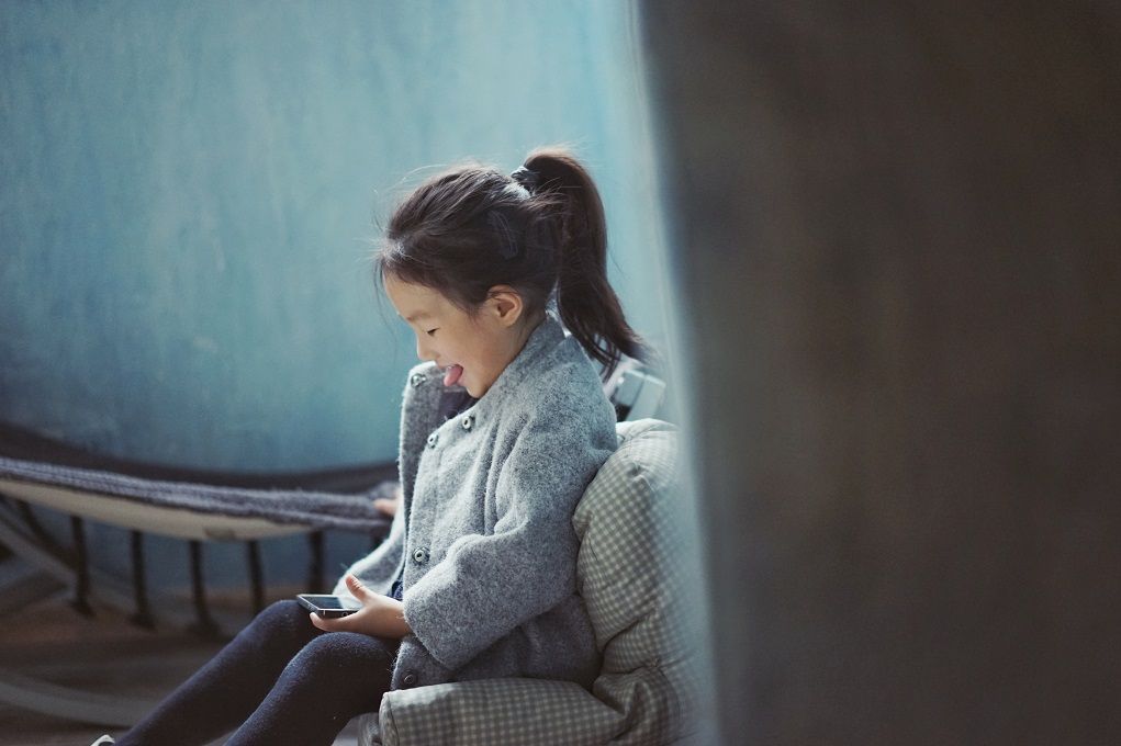 Jong meisje kijkt naar telefoon