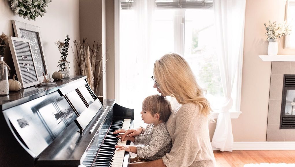 Moeder speelt piano met haar jonge kind