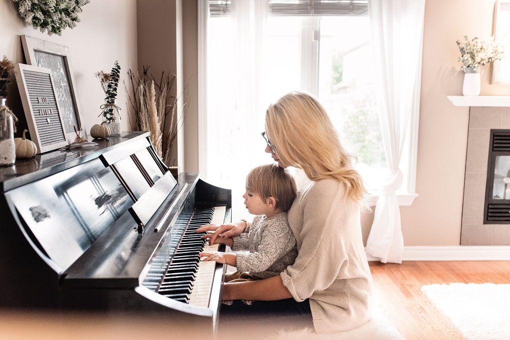 Moeder speelt piano met haar jonge kind
