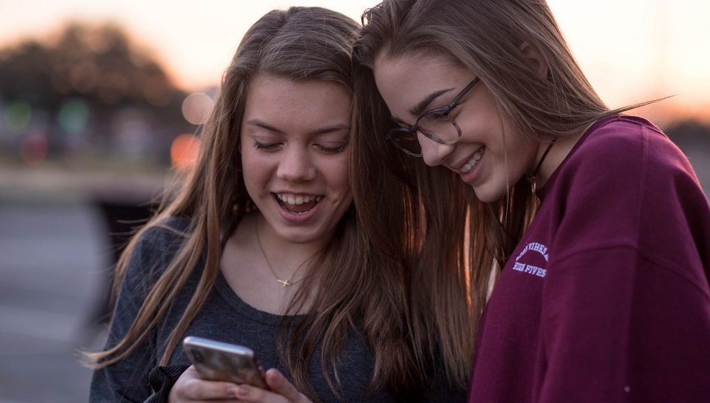 Jonge meisjes kijken op hun telefoon in een mogelijk geval van grooming
