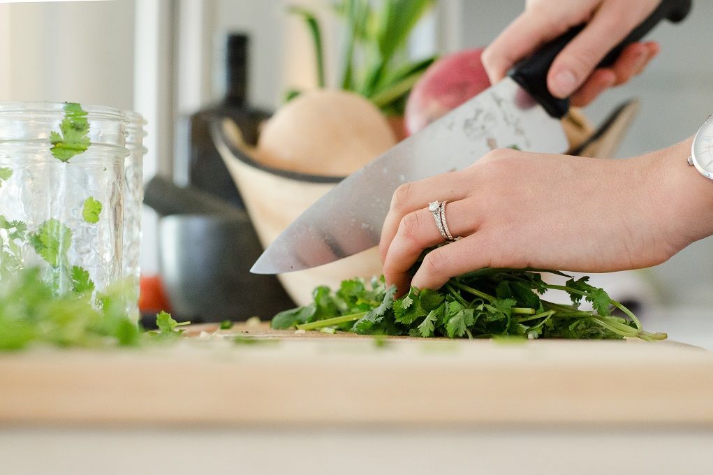 Vrouw snijdt groente met koksmes